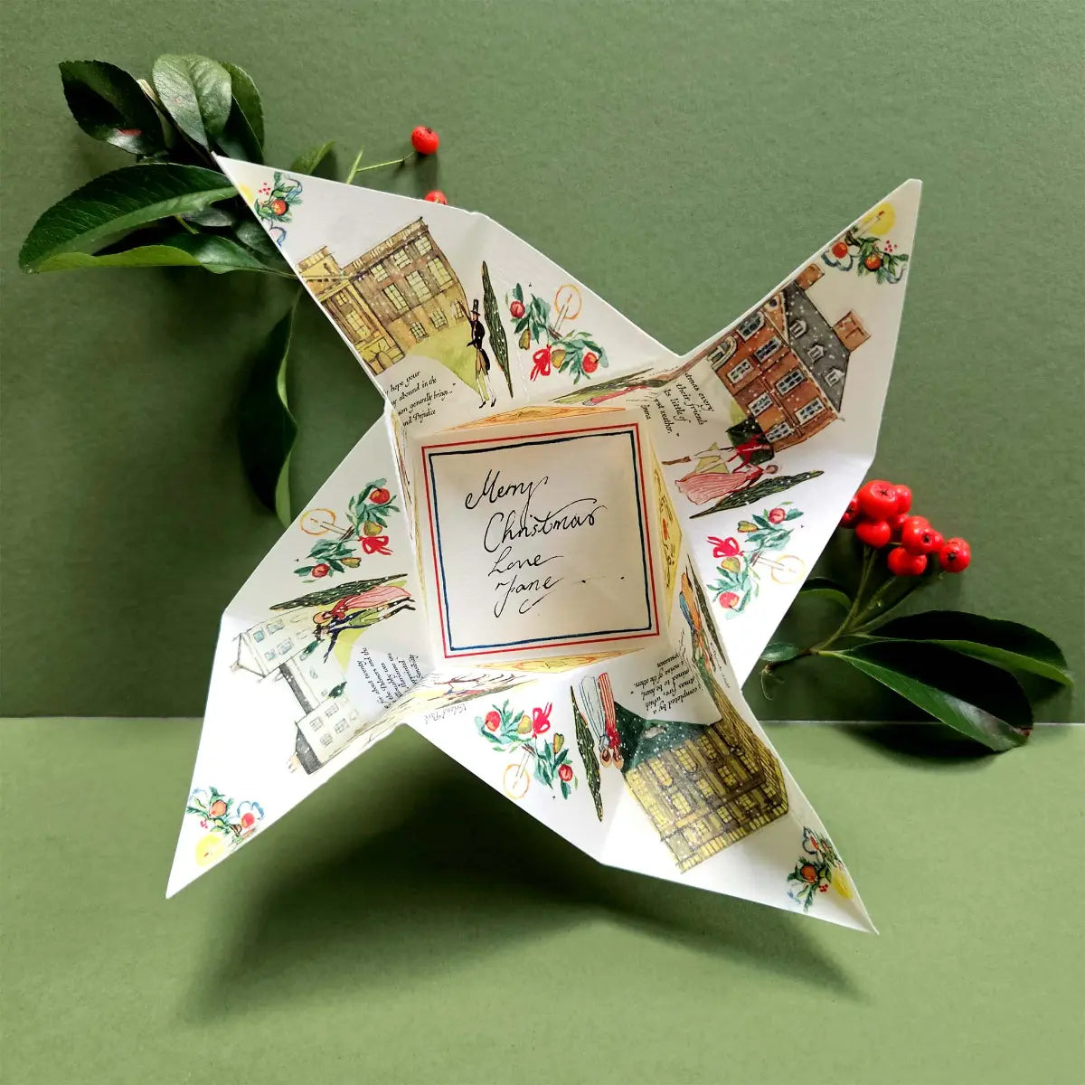 Decorative paper star with regency-style Christmas illustrations on a green background