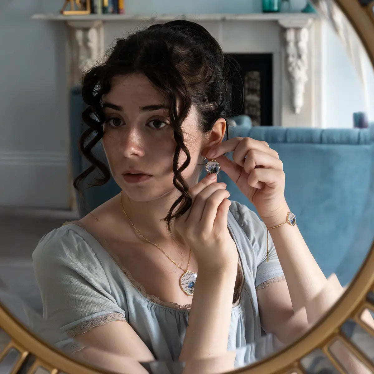 Model wearing matching book page earrings, necklace and bracelet.