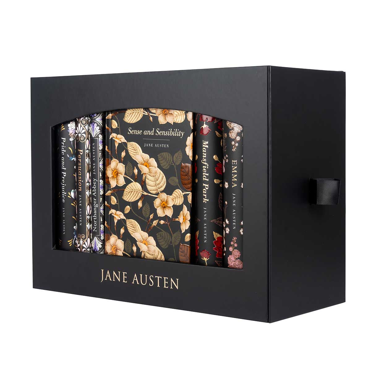 Side view, right: The Jane Austen Boxset contains all six of Jane Austen's published novels, in a black matte case and scribed with 'Jane Austen' in gold, serif letters. There is a black ribbon attached to the box to slid the inside box out.