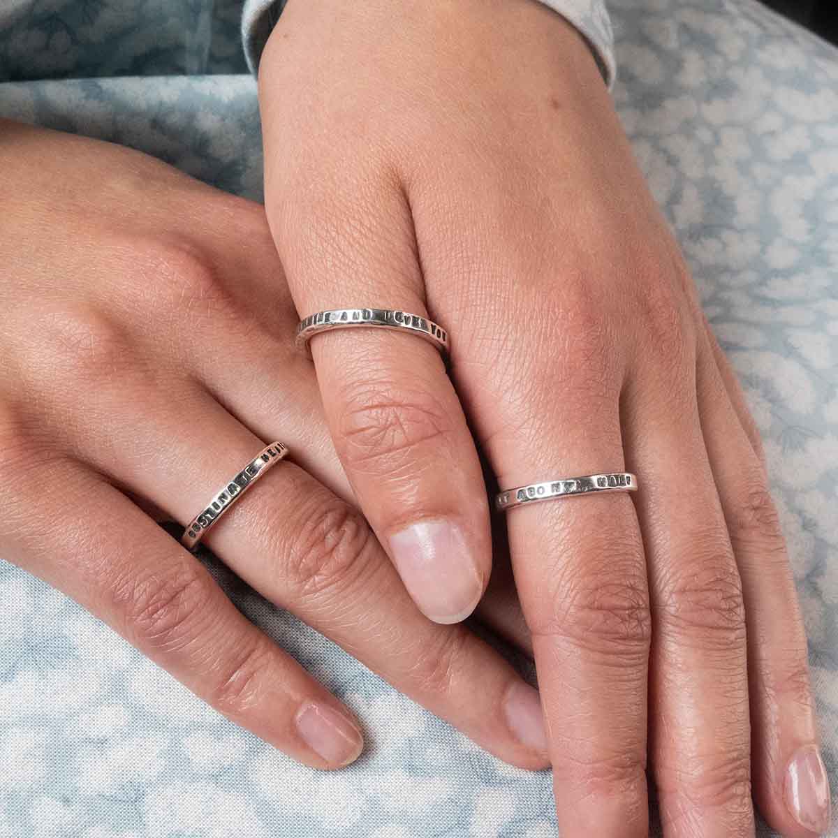 Three of our quote rings worn on hands.