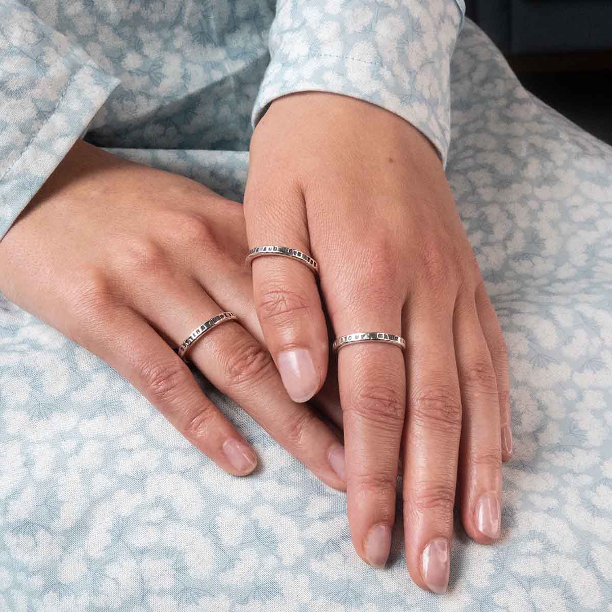 Three of our quote rings worn on hands.