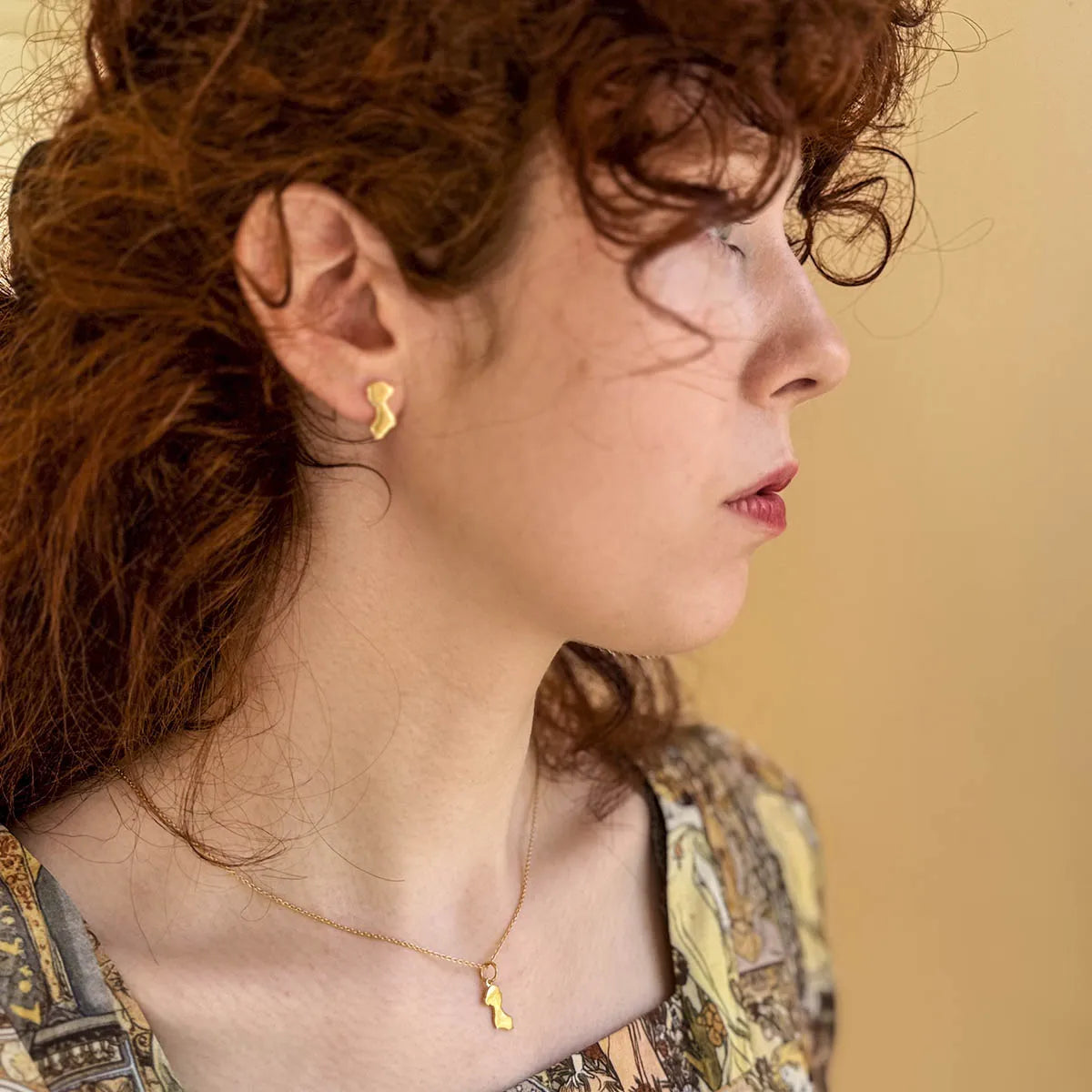 Jane Austen Gold Silhouette Pendant earring on woman