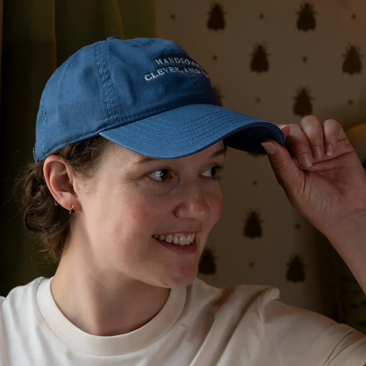 Woman wearing blue Jane Austen themed baseball cap