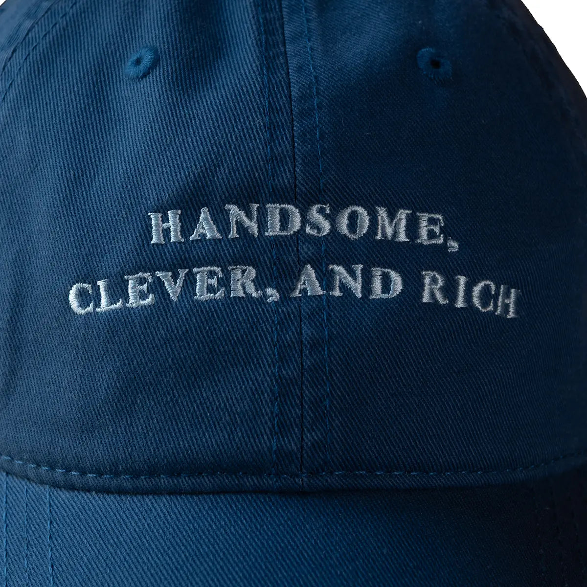 Close up on 'Handsome, Clever, and Rich' detail on the Jane Austen quote cap