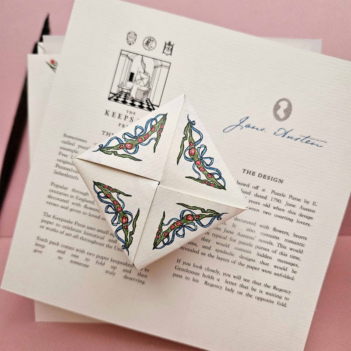 Decorative paper with intricate designs and text on a pink background