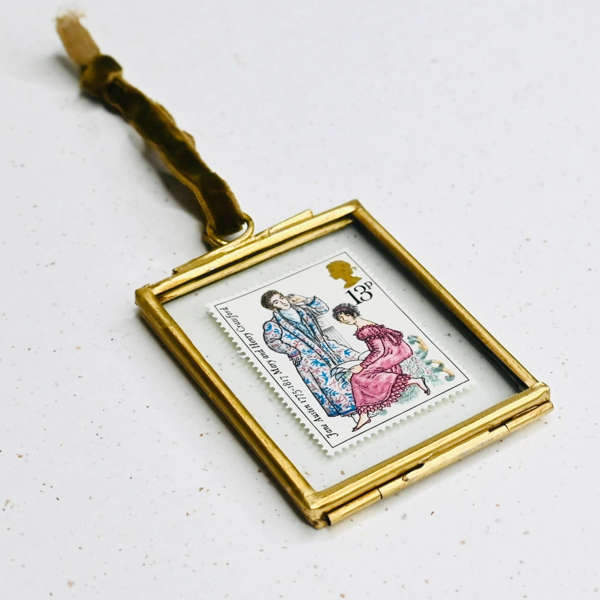 Gold-framed postage stamp with a couple illustration on a white, speckled background.