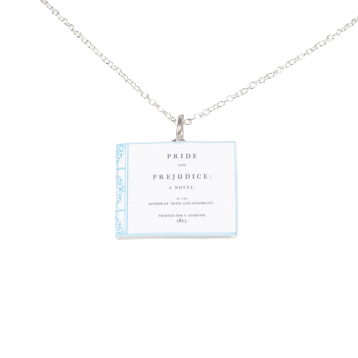 Closeup of necklace that looks like the First Edition book cover of Pride and Prejudice