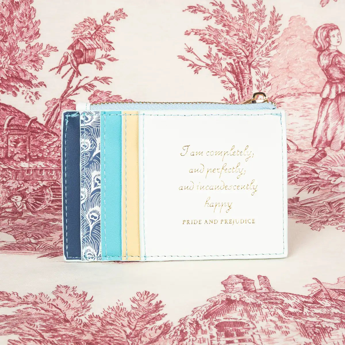 Card holder side of wallet in colours of cream, pale yellow, blues and a pattern of peacock feathers.