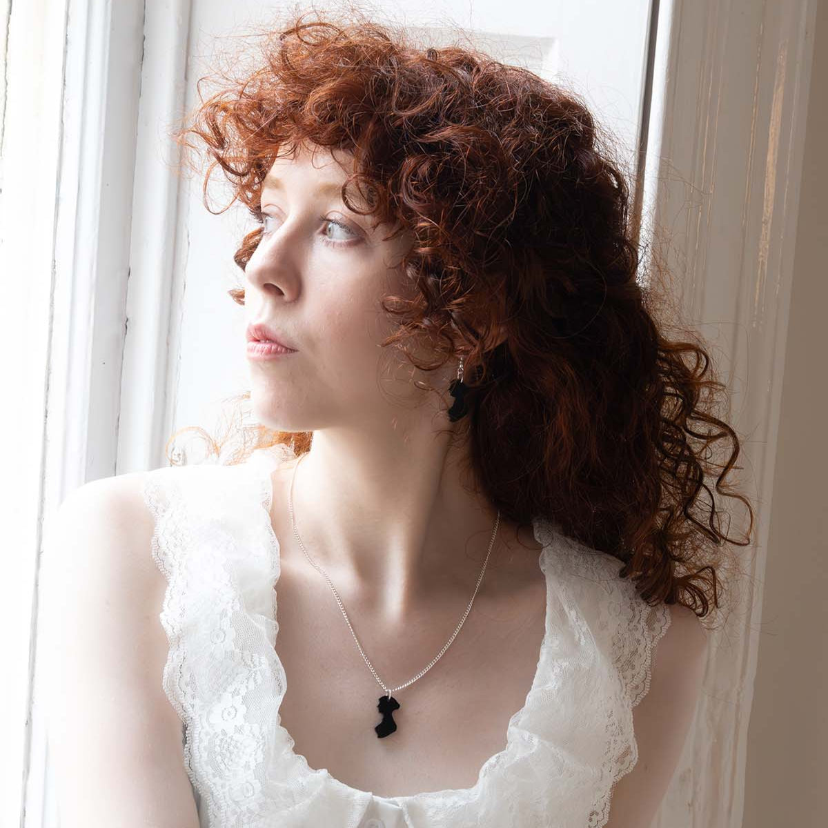 Black acrylic necklace in the shape of Jane Austen's silhouette on a womans neck