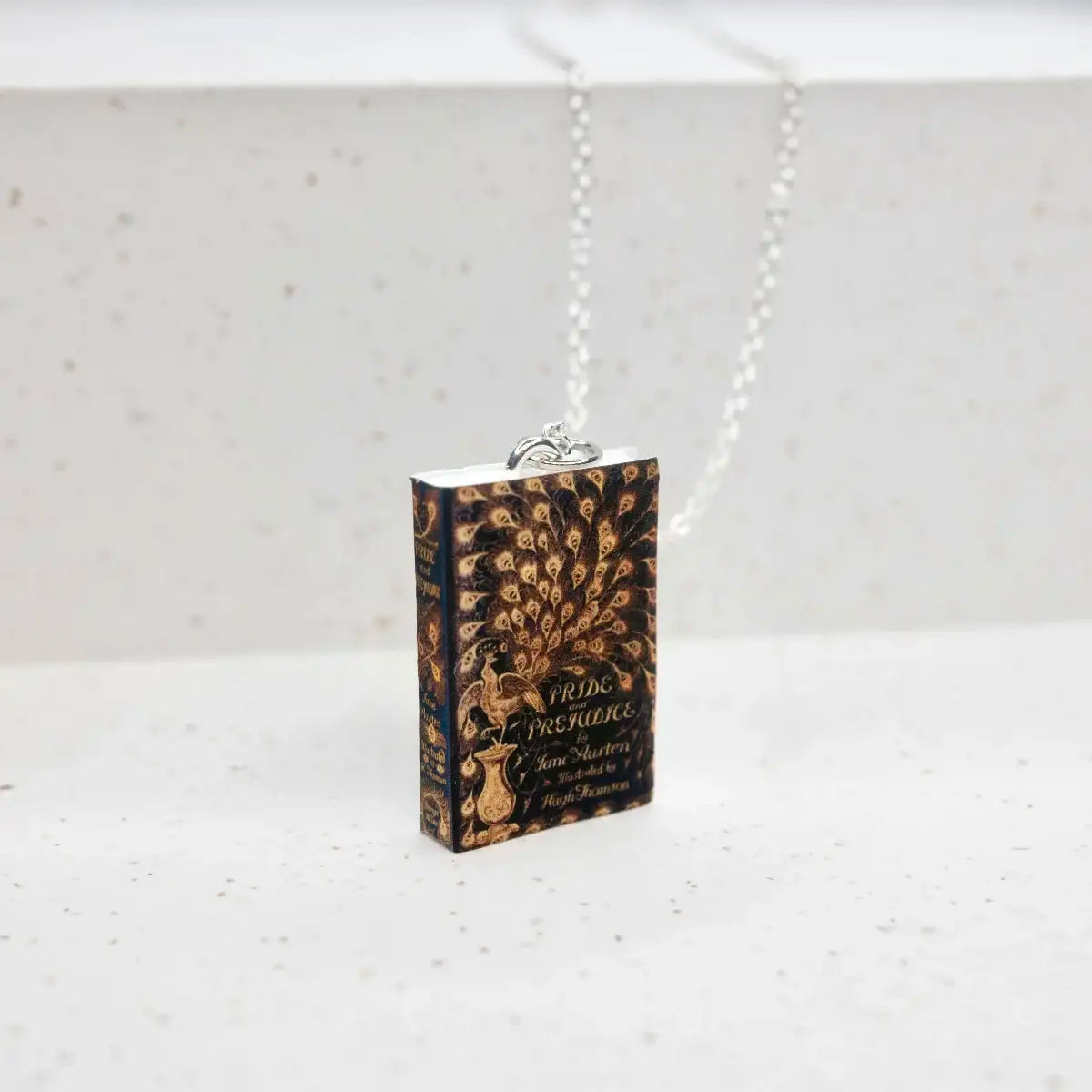 book cover necklace on rough stone surface
