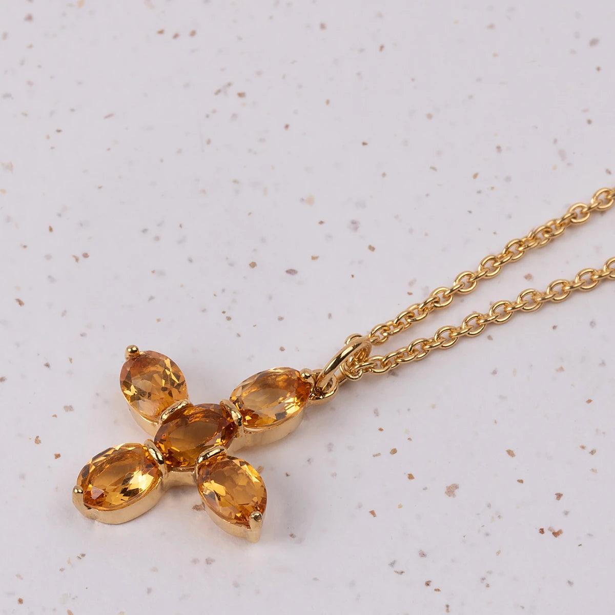 Close up of Jane Austen Citrine replica Topaz cross on a gold platec Necklace