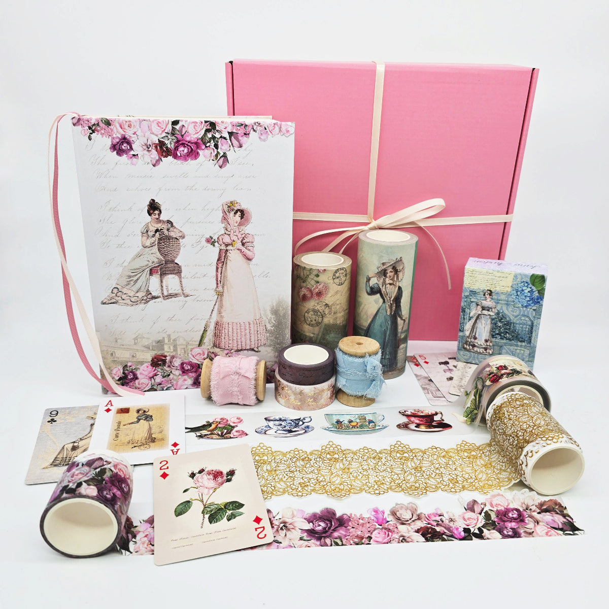 Collection of stationery items including a pink box, cards, and decorative tapes on a white background