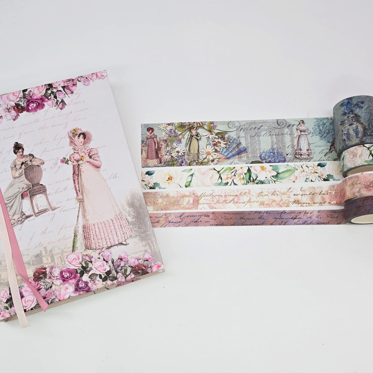 Decorative notebook and washi tape with vintage-style illustrations on a white surface