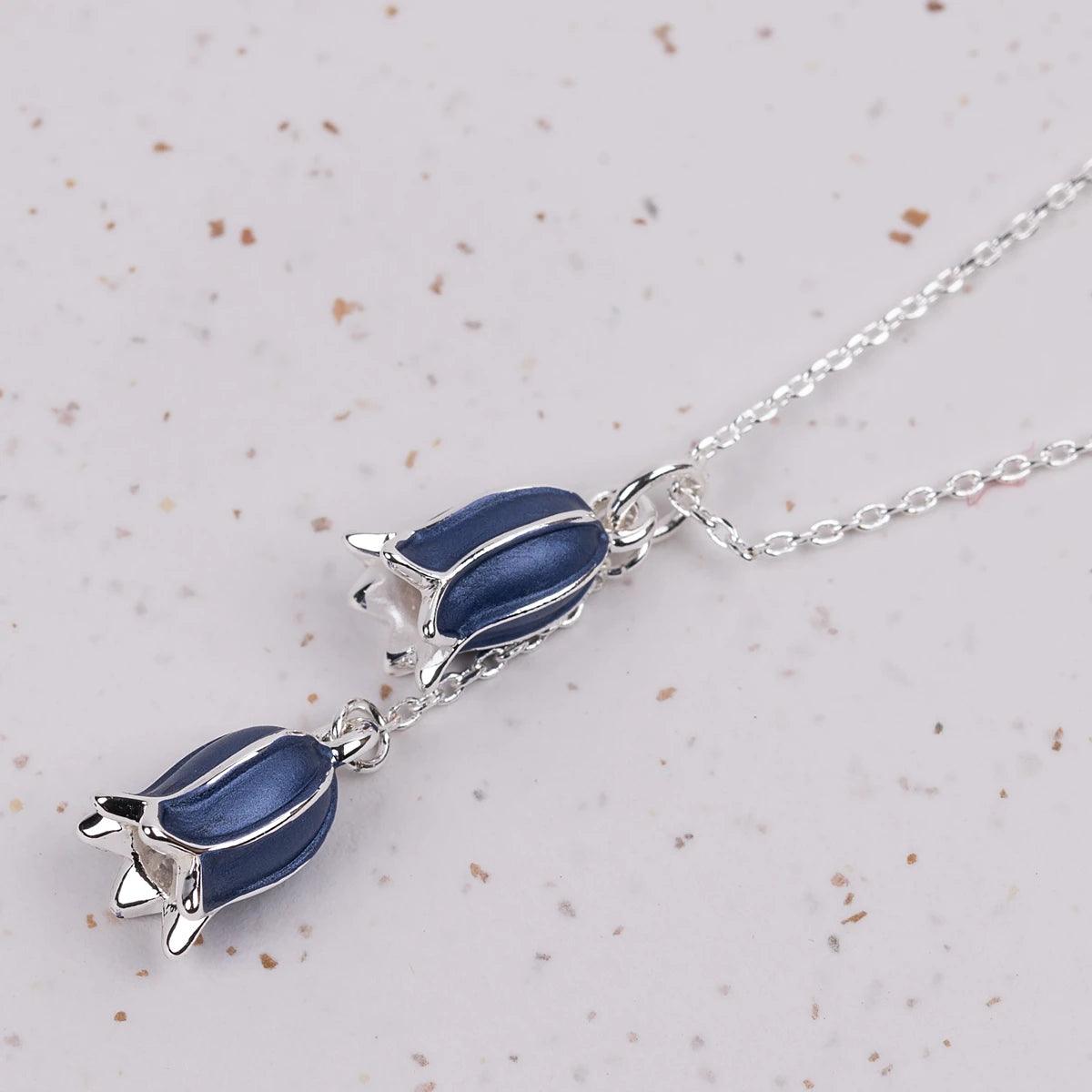 Close up of 2 bluebells on a silver necklace
