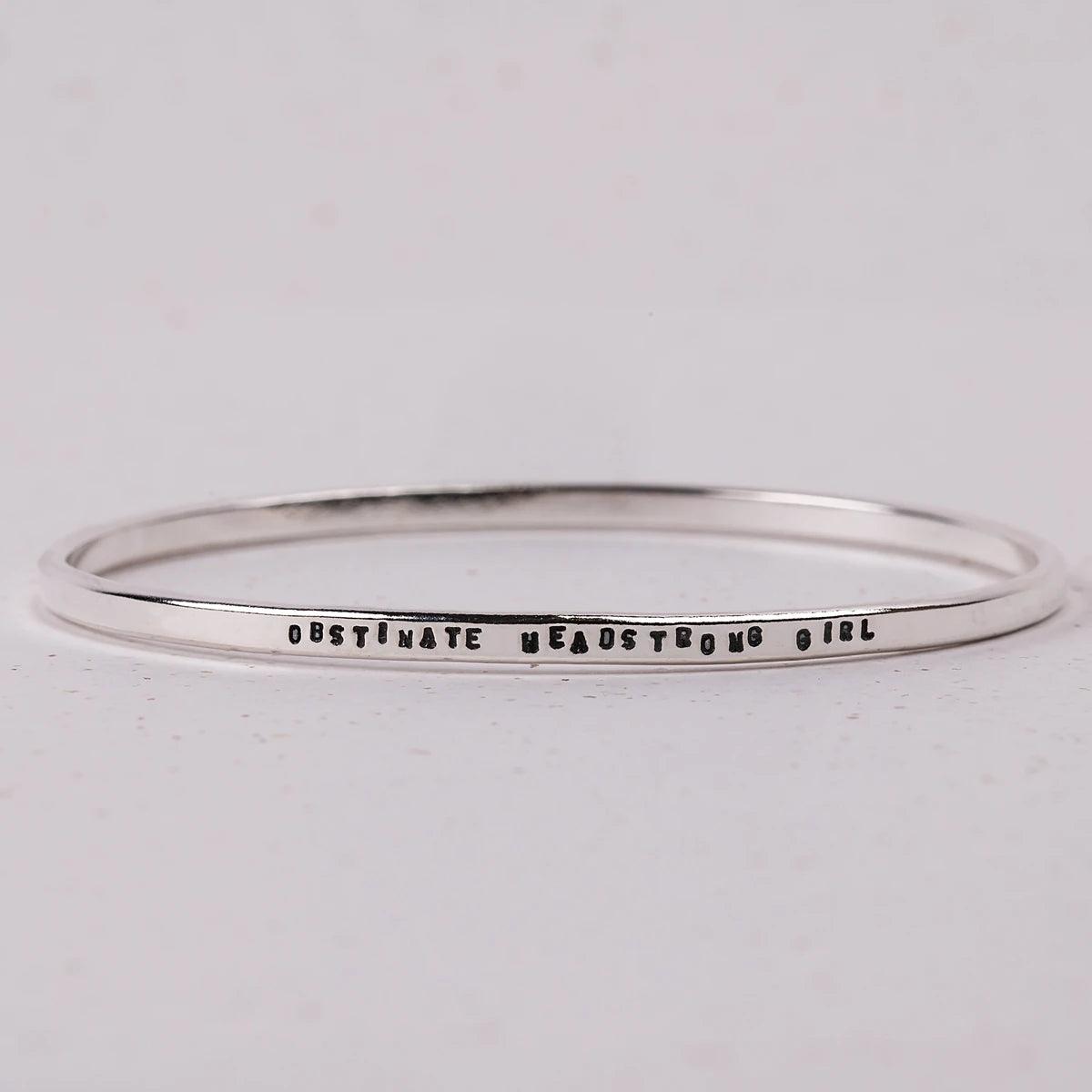 Bracelet wih "Obstinate Headstrong Girl" stamped into it