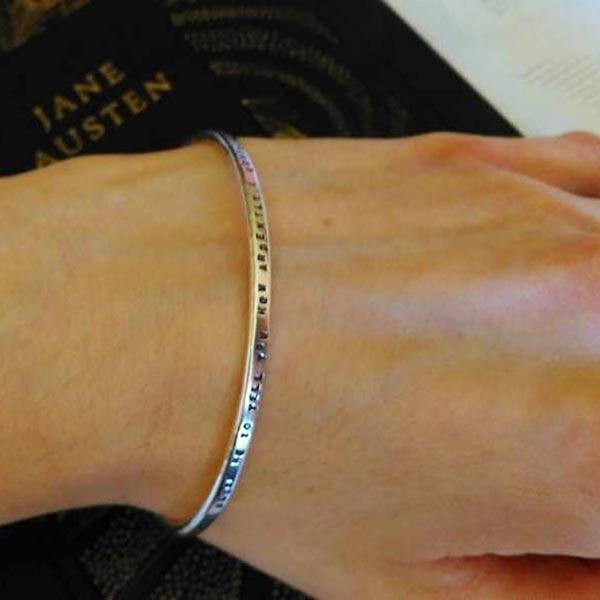 Bracelet on arm with words  "If I loved you less, I might be able to talk about it more"