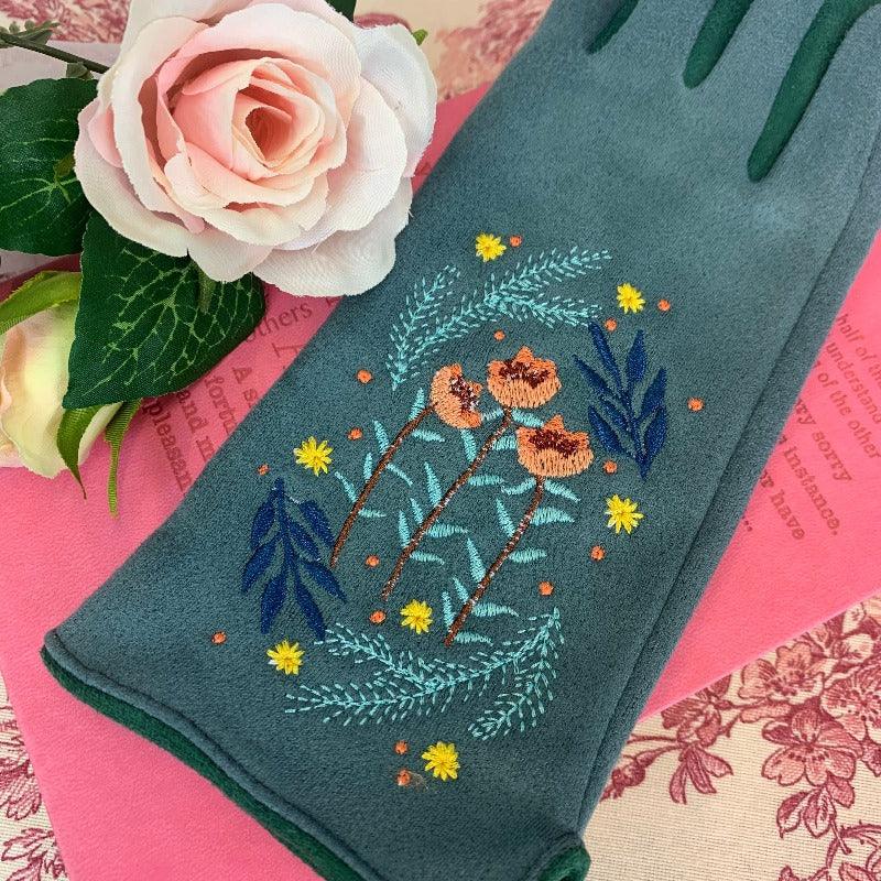 Green cotton gloves with pink, green, blue, and yelllow embroidered design on it, reminiscent of regency embroidery designs
