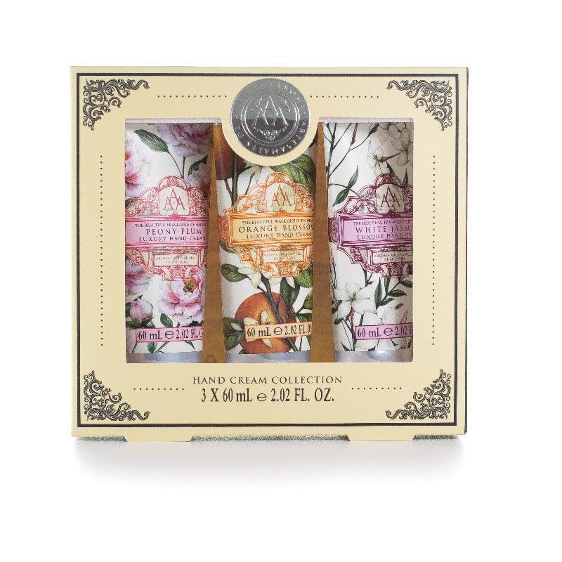 A delicately decorated box, houses three hand creams. Peony plum, orange blossom, and white jasmine. All with summery fruitful designs on the tubes. With a blank background behind