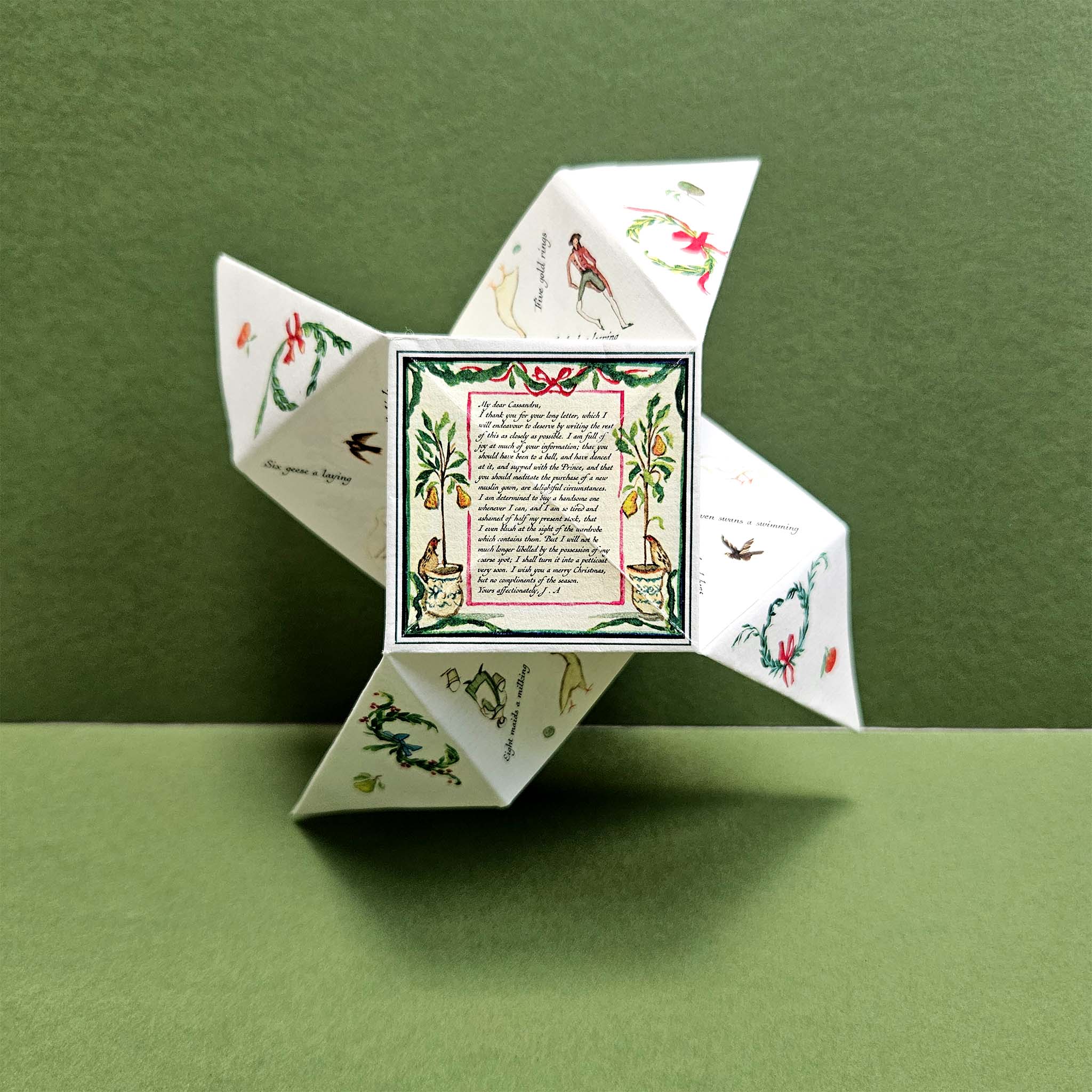 Decorative paper fortune teller with Christmas illustrations on a green background