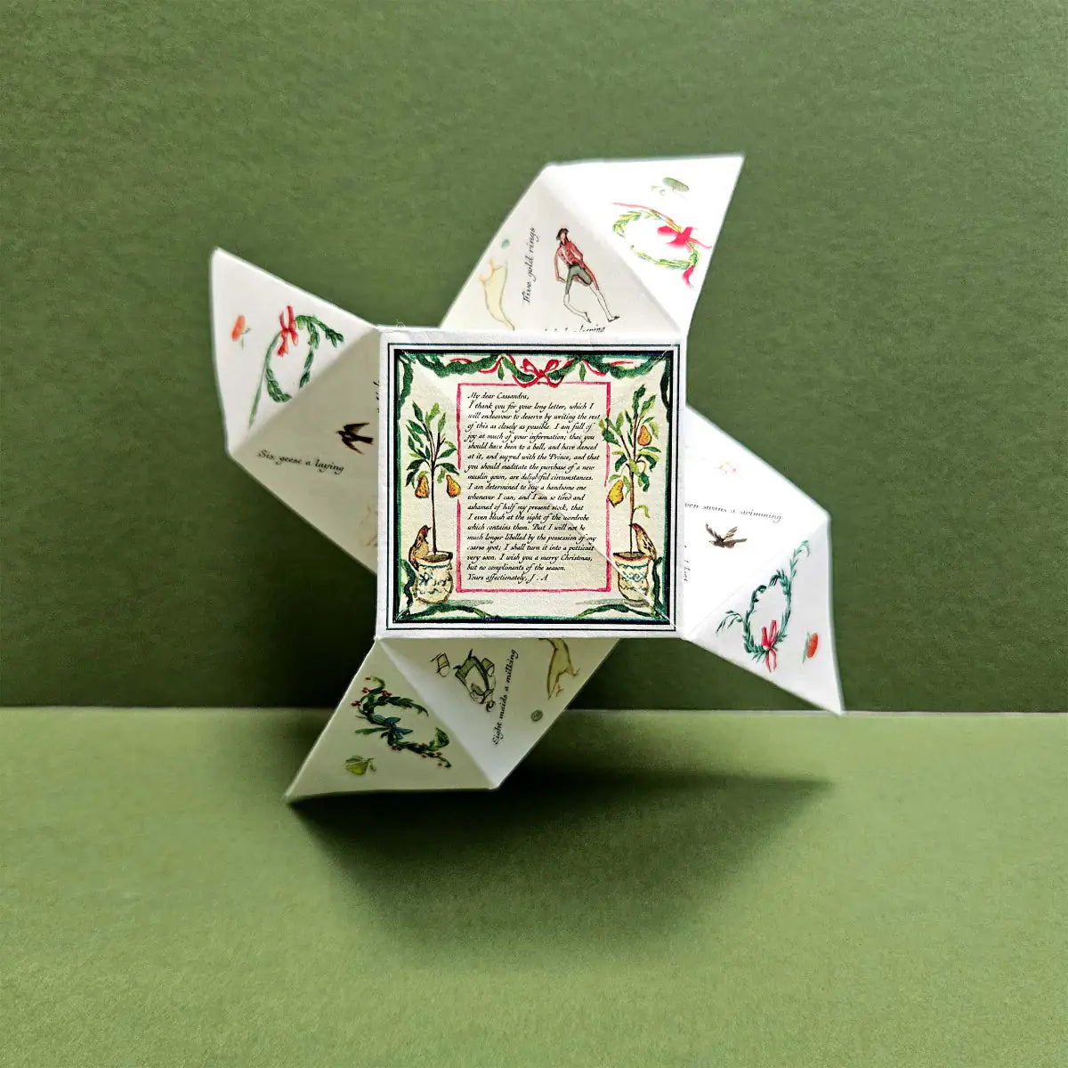 Decorative paper fortune teller with Christmas illustrations on a green background