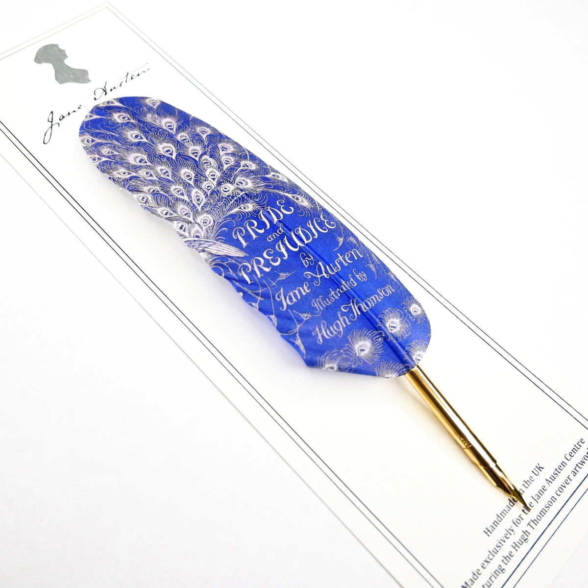 A blue feather quill with gold gilded nib, printed with text on paper backing, at a slight angle.