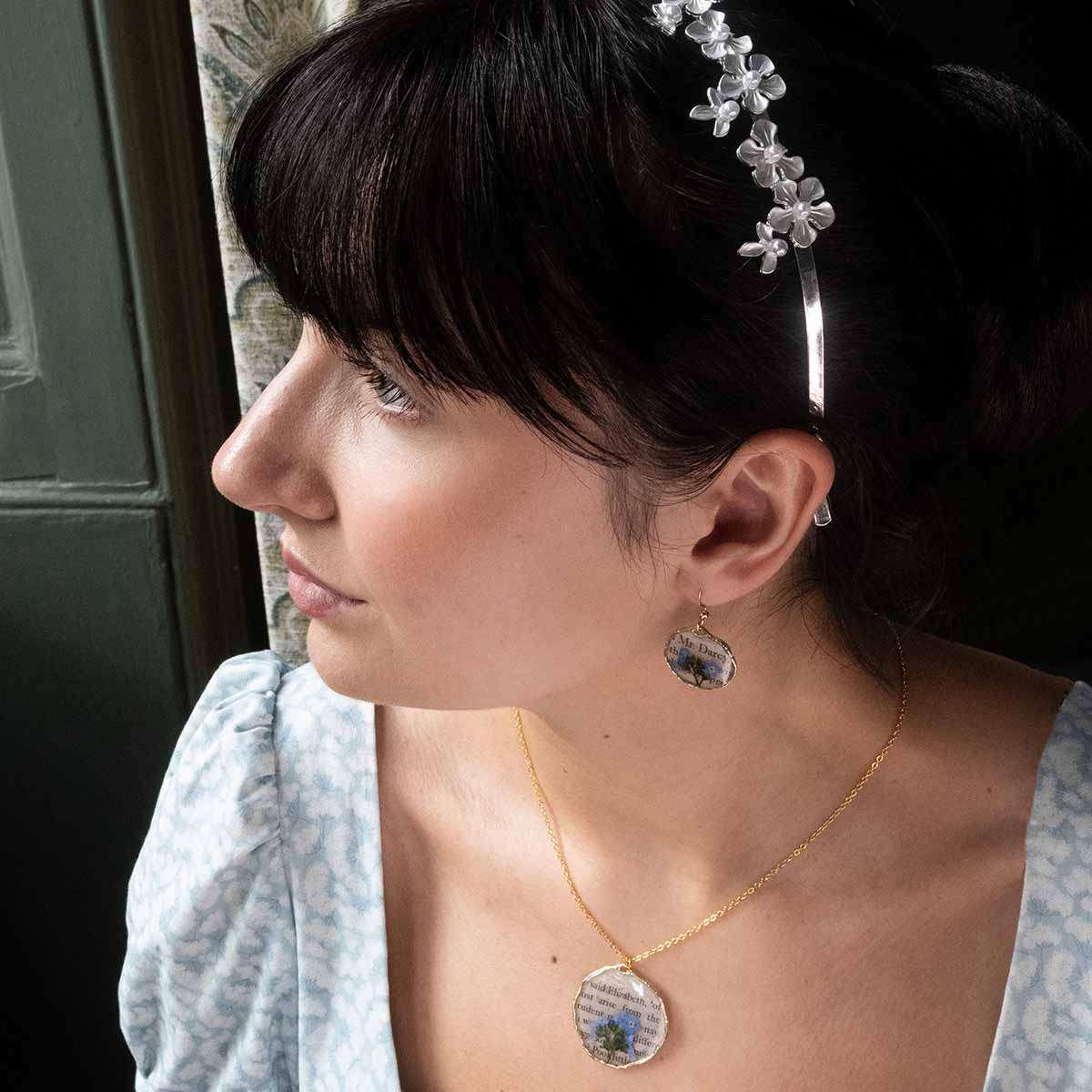 Catherine Morland modelling Book Page Earrings and Necklace, gazing out of a window (2)