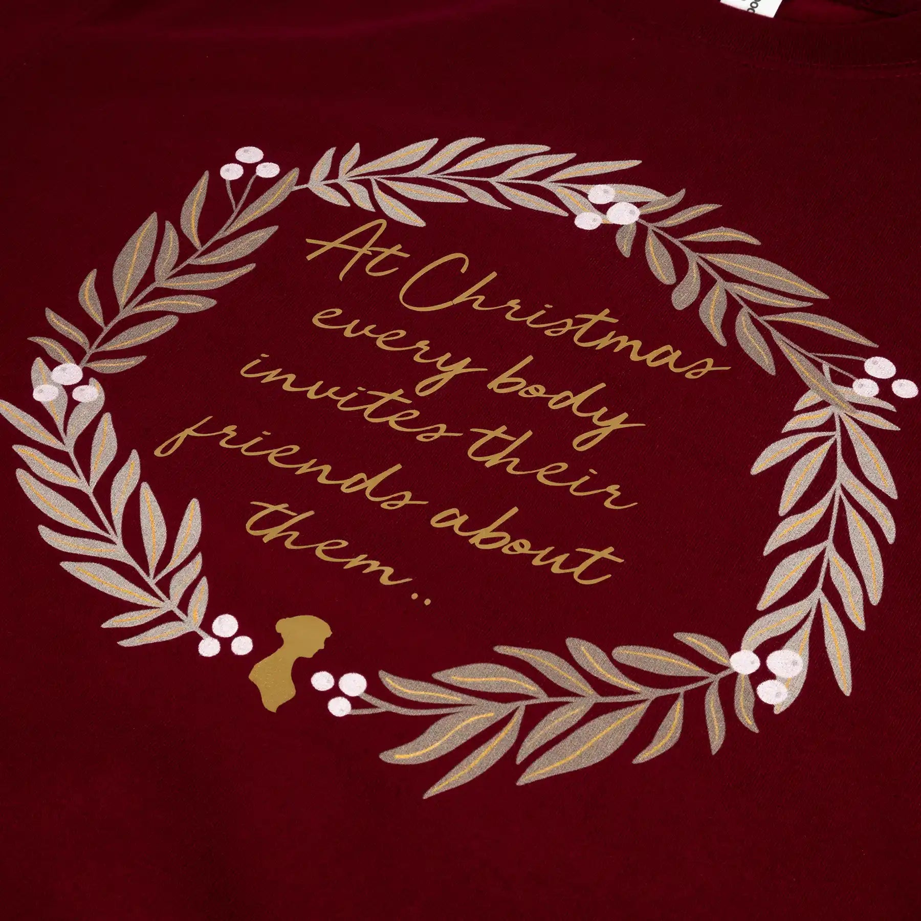 Closeup of Burgudy sweater featuring a wreath of mistletoe and quote "At Christmas everybody invites their friends about them"