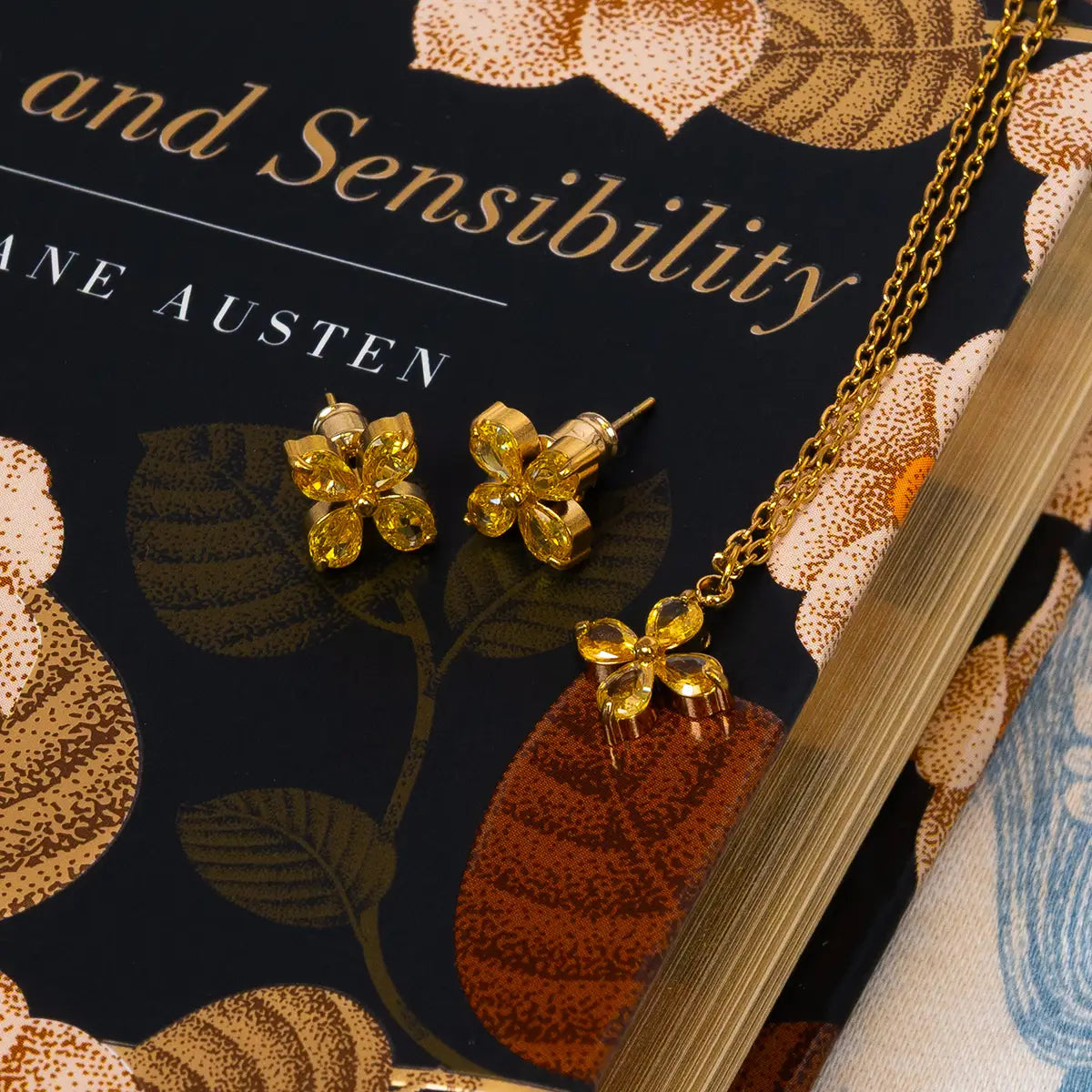 Matching earring and necklace jewellery set placed on a hardback copy of sense and sensibility.