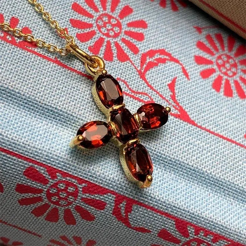 Garnet Cross Necklace on a cloth background