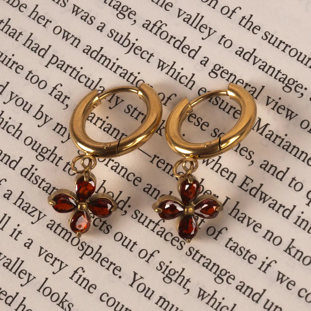 Elizabeth Bennett huggie earrings on a book