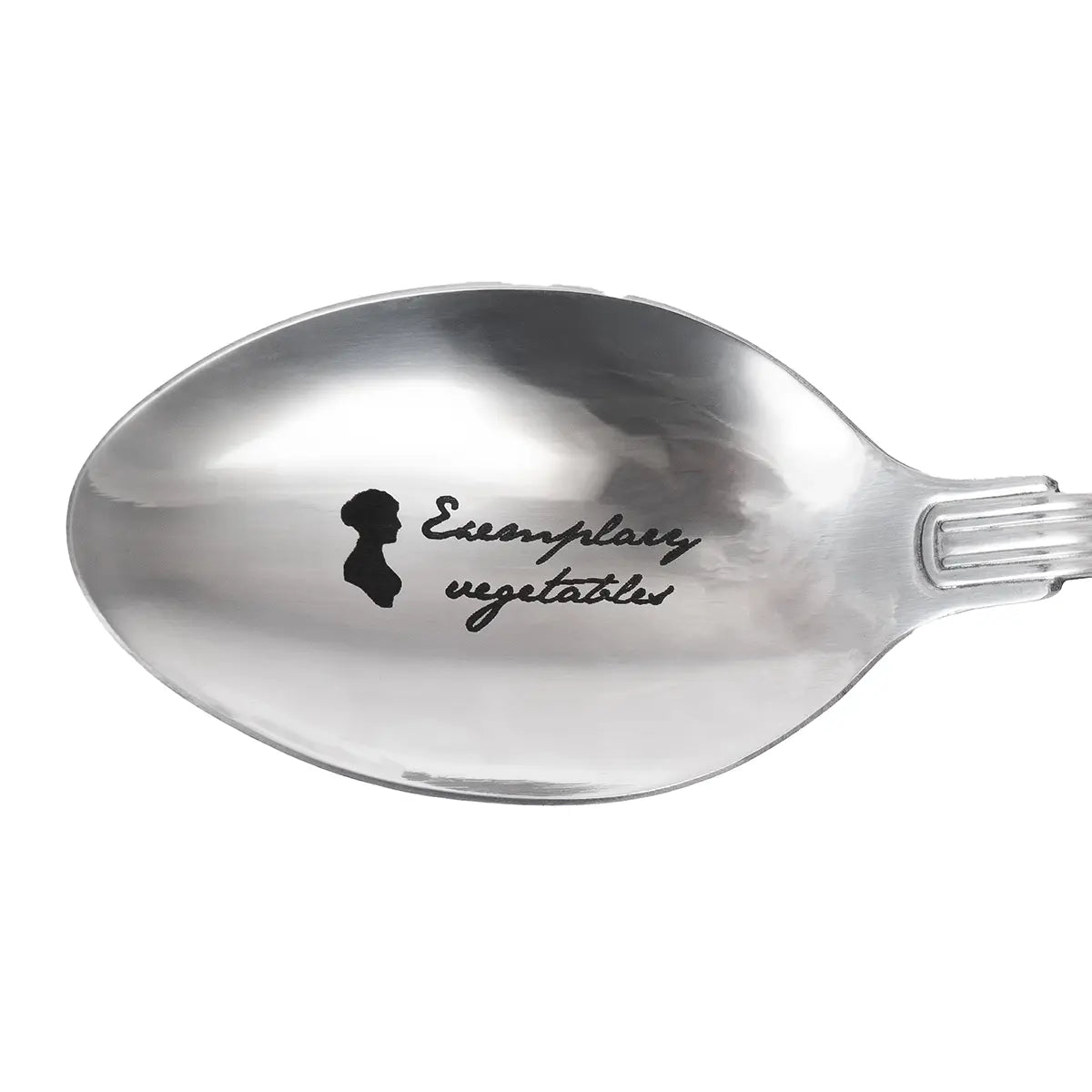 Close up of silver spoon with 'examplary vegetables' printed on it against a white background