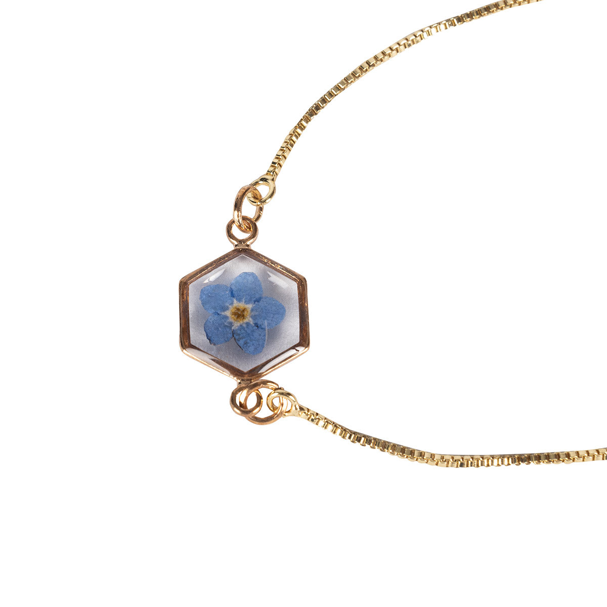 Close up of a Forget Me Not Flower Bracelet with gold chain, hexagonal frame featuring a pressed Forget Me Not Flower