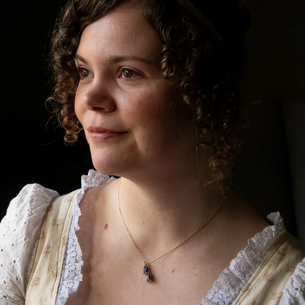 Woman wearing a white lace dress with a dark background