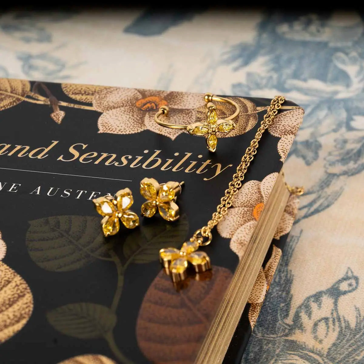 Matching earring and necklace jewellery set placed on a hardback copy of sense and sensibility.