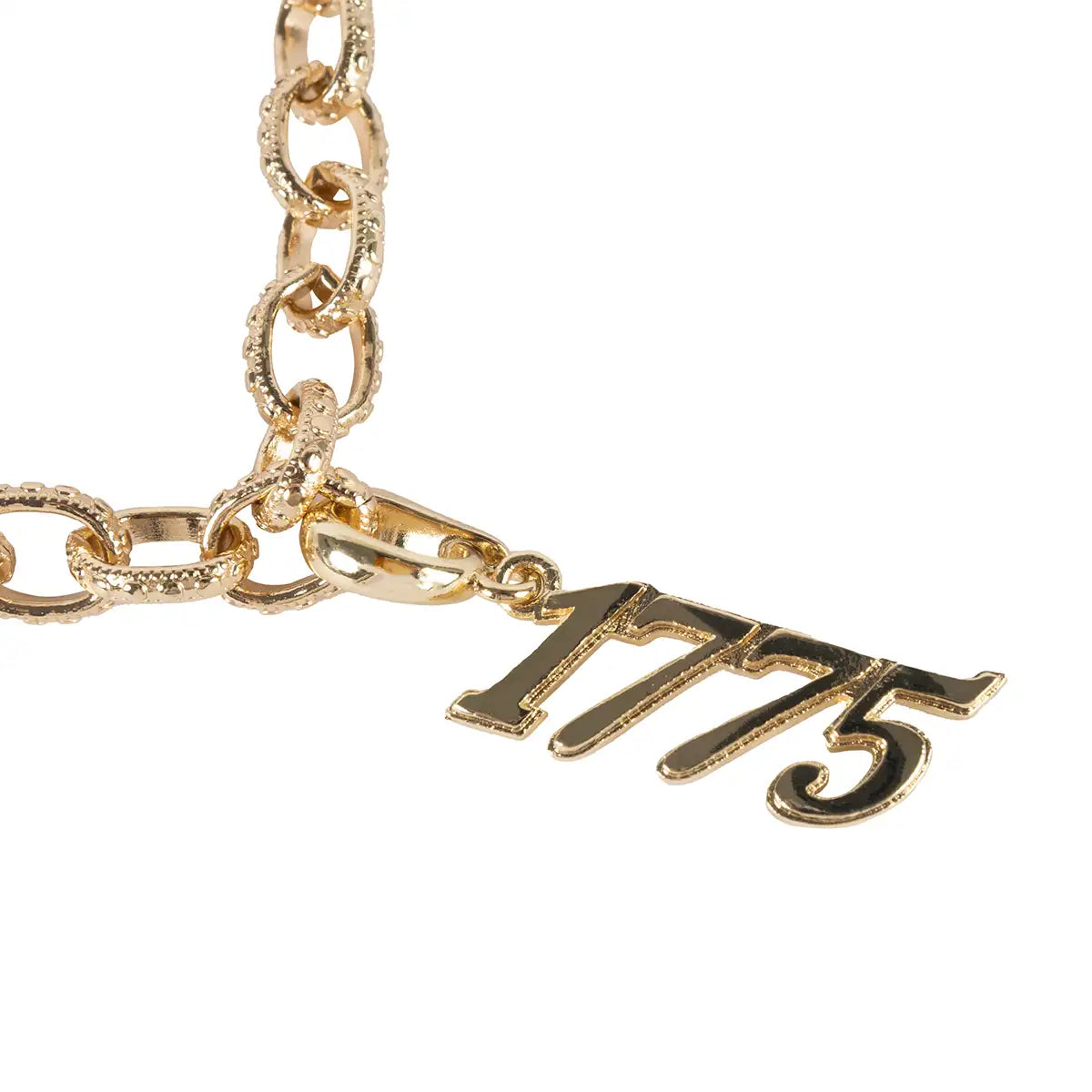 Gold chain bracelet with a '1775' charm on a white background