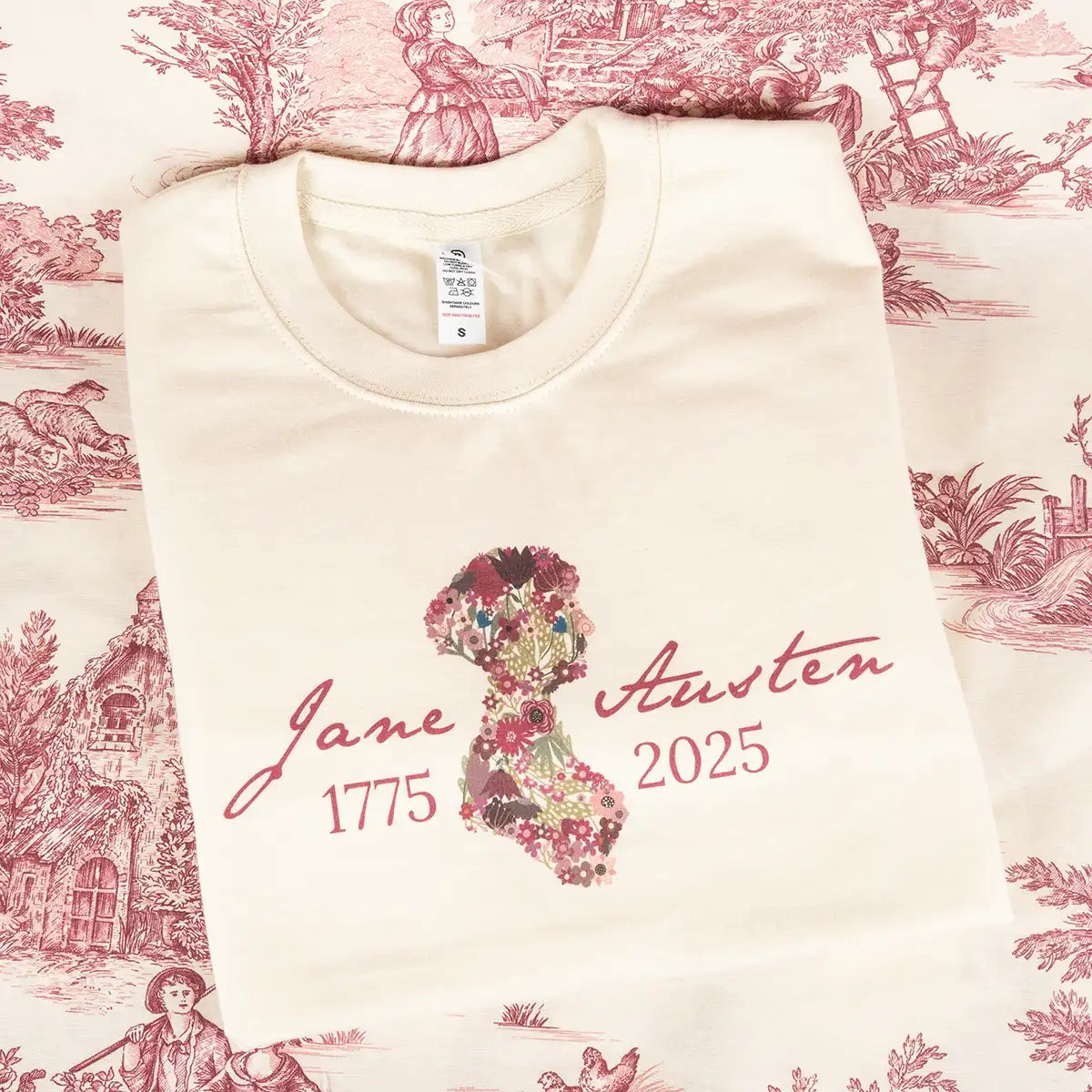 Cream Jane Austen-themed sweatshirt with burgundy pattern and text reading 1775-2025