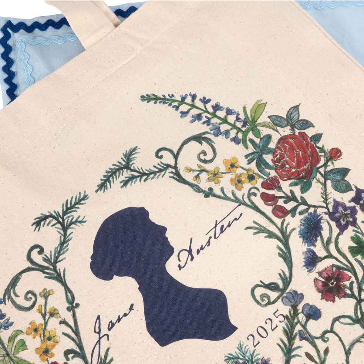Close-up image of the Tote Bag anniversary pattern - navy Jane Austen silhouette surrounded by delicately painted flowers and ferns