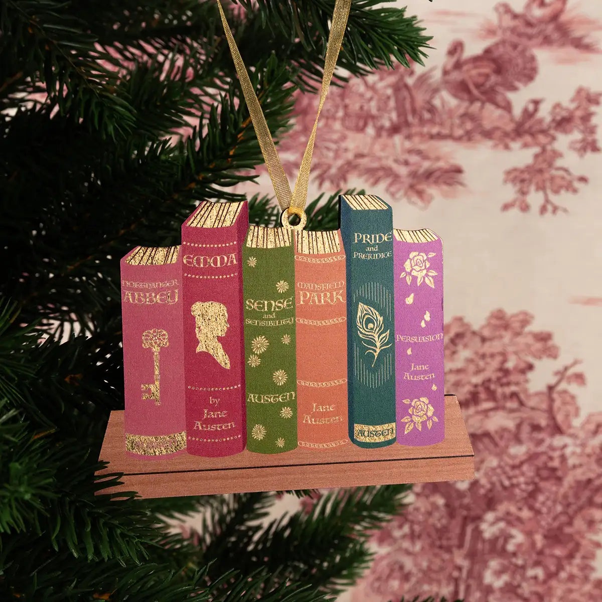 Ornament shaped like a wooden bookshelf with books on a Christmas tree.