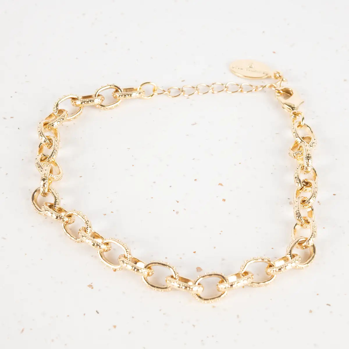 Gold chain bracelet on a light background