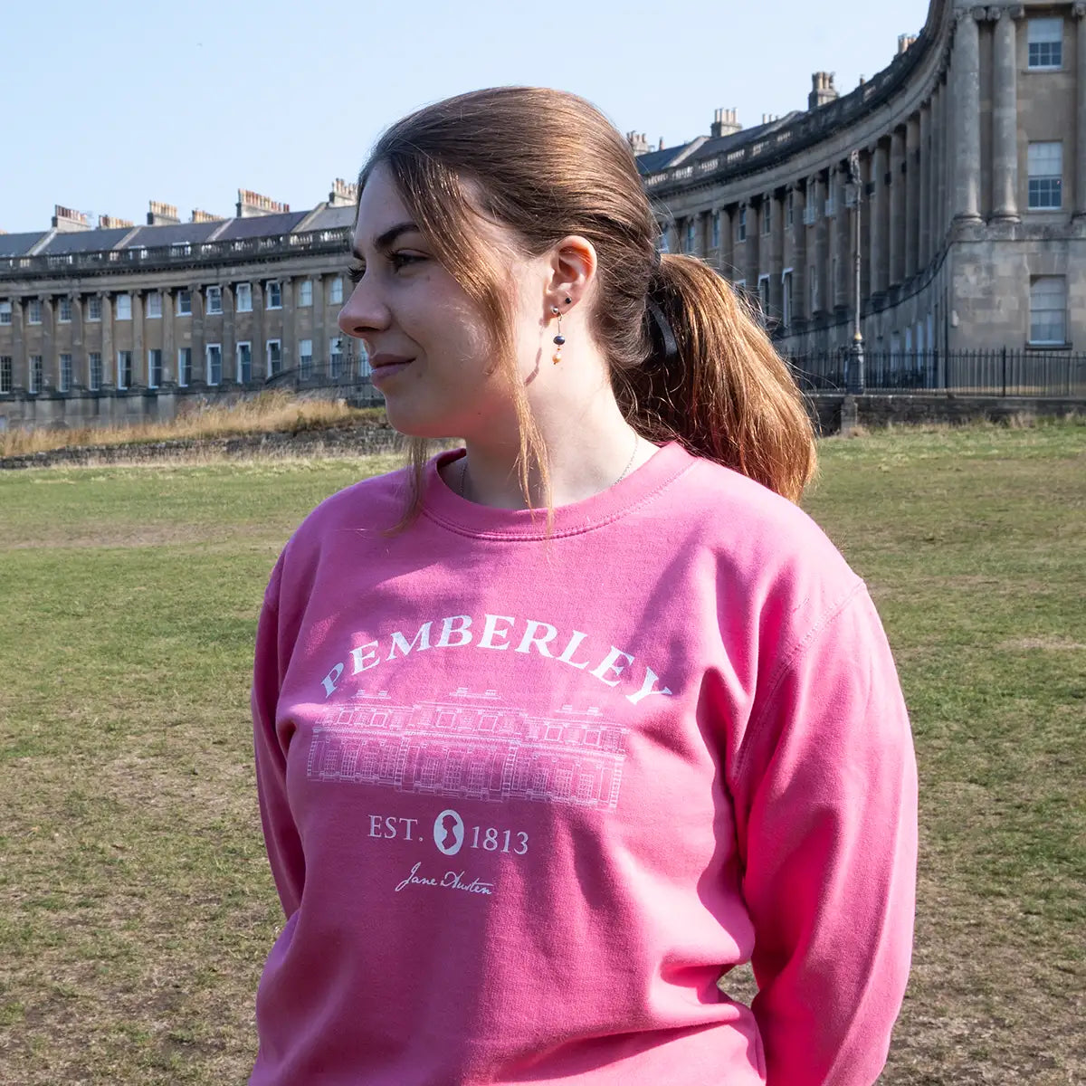 Model wearing pink Pemberley sweater by the Royal Crescent in Bath