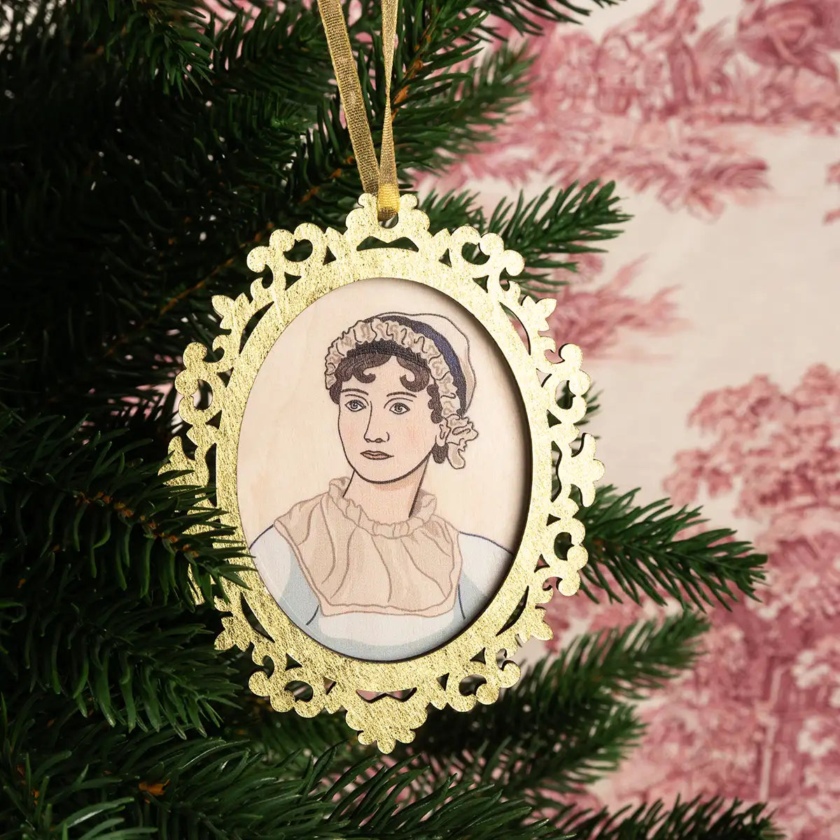 Jane Austen wooden portrait in a golden wood frame hanging from a Christmas tree
