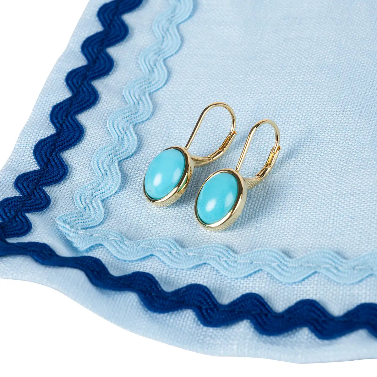 Earrings on blue fabric