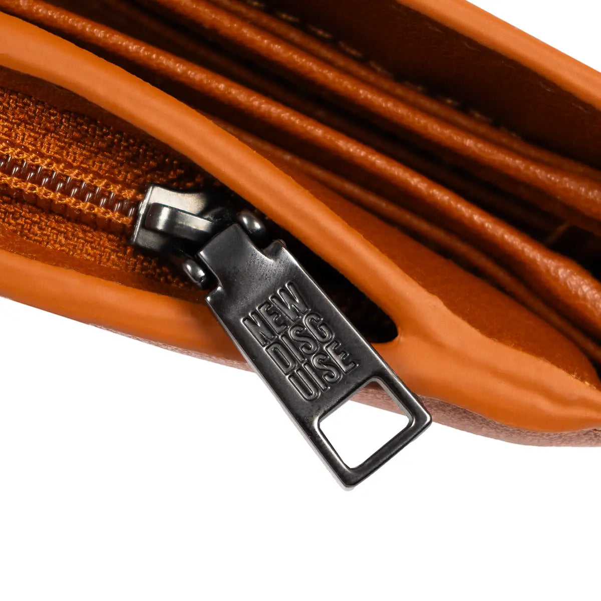 Close up of New Disguise zip detail on tan Jane Austen flap over purse