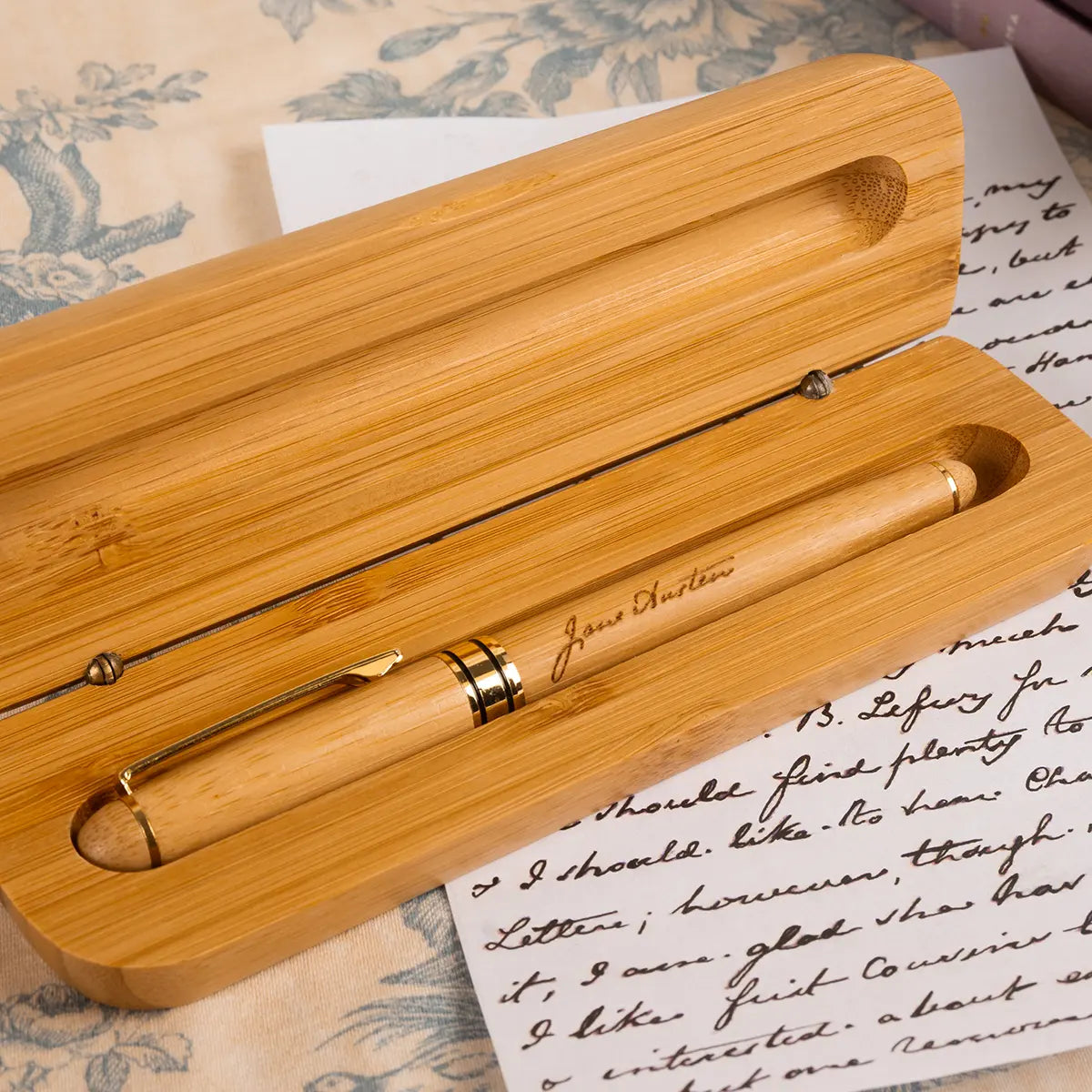Wooden Jane Austenthemed fountain tip pen in wooden case on top of a handwritten replica of one of Jane Austen's personal letters