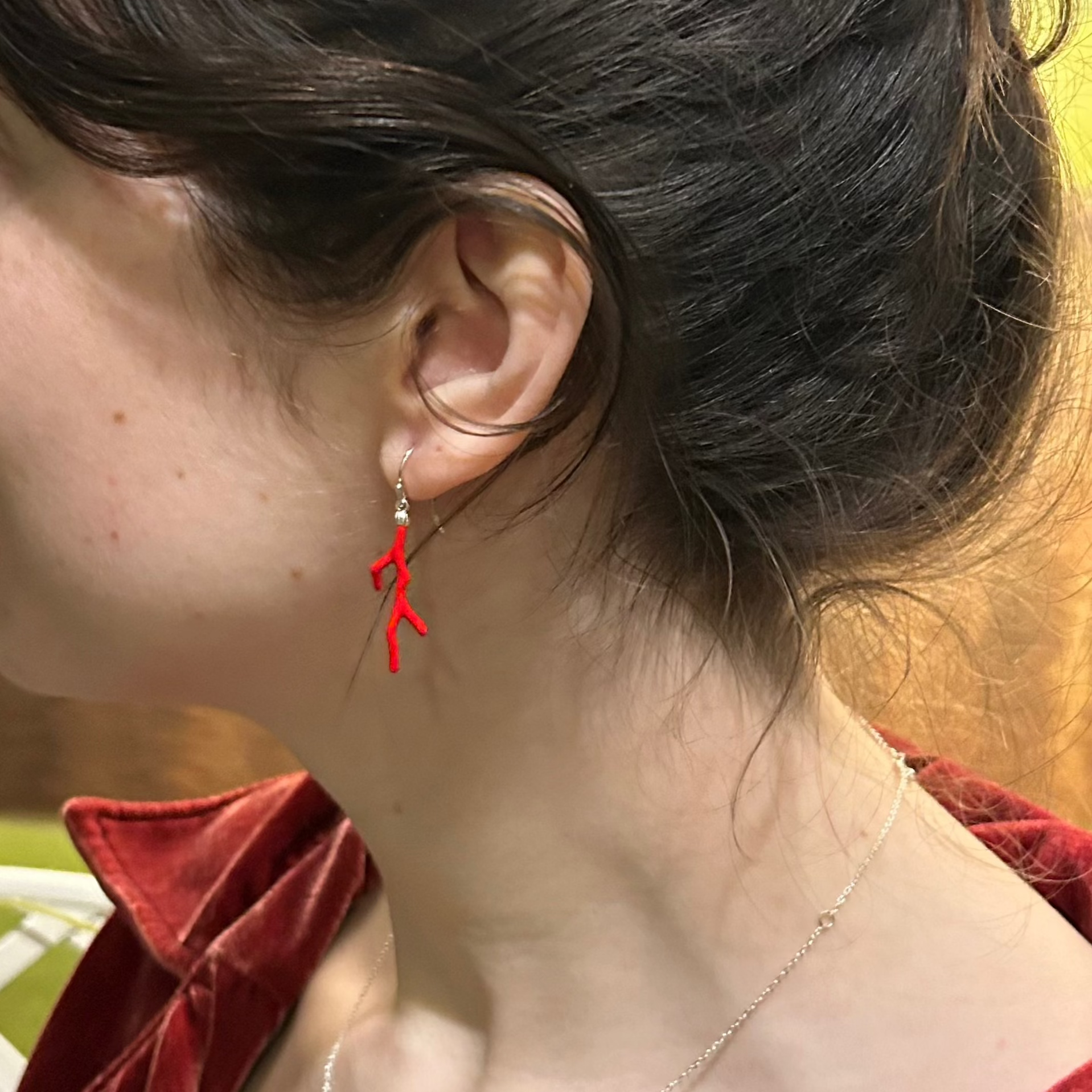 Actress in red regency outfit with red earrings