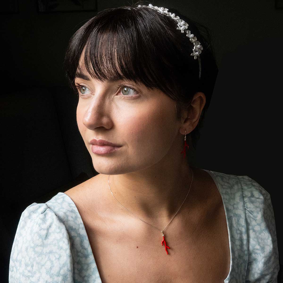 Model wearing the coral necklace and matching earring. Model wears a Regency dress and headband.