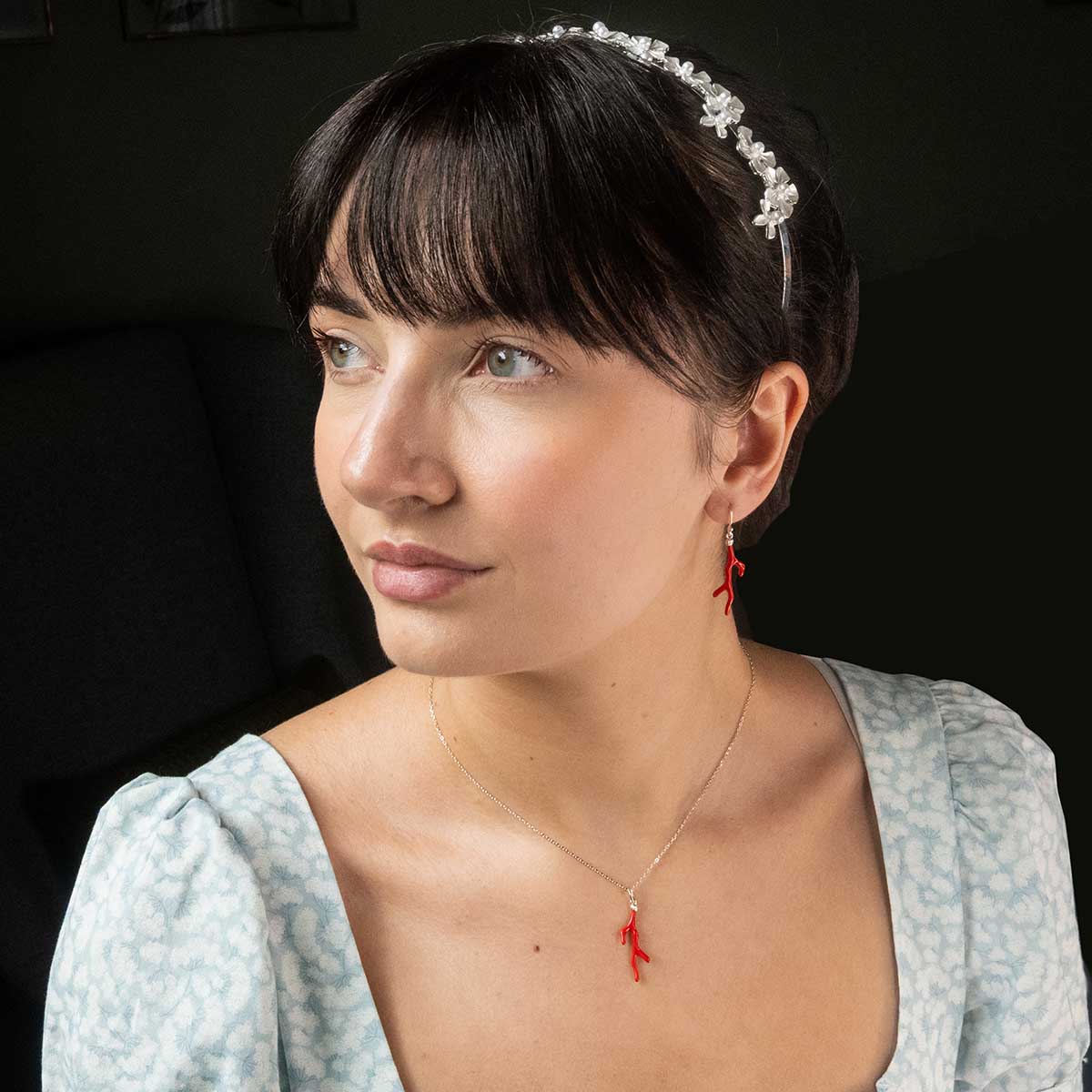 Model wearing the coral necklace and matching earring. Model wears a Regency dress and headband.