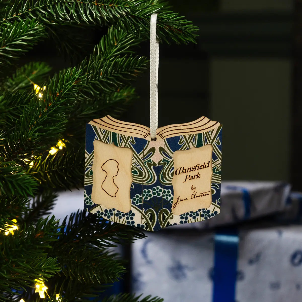 Decorative book ornament with 'Mansfield Park' on a Christmas tree.