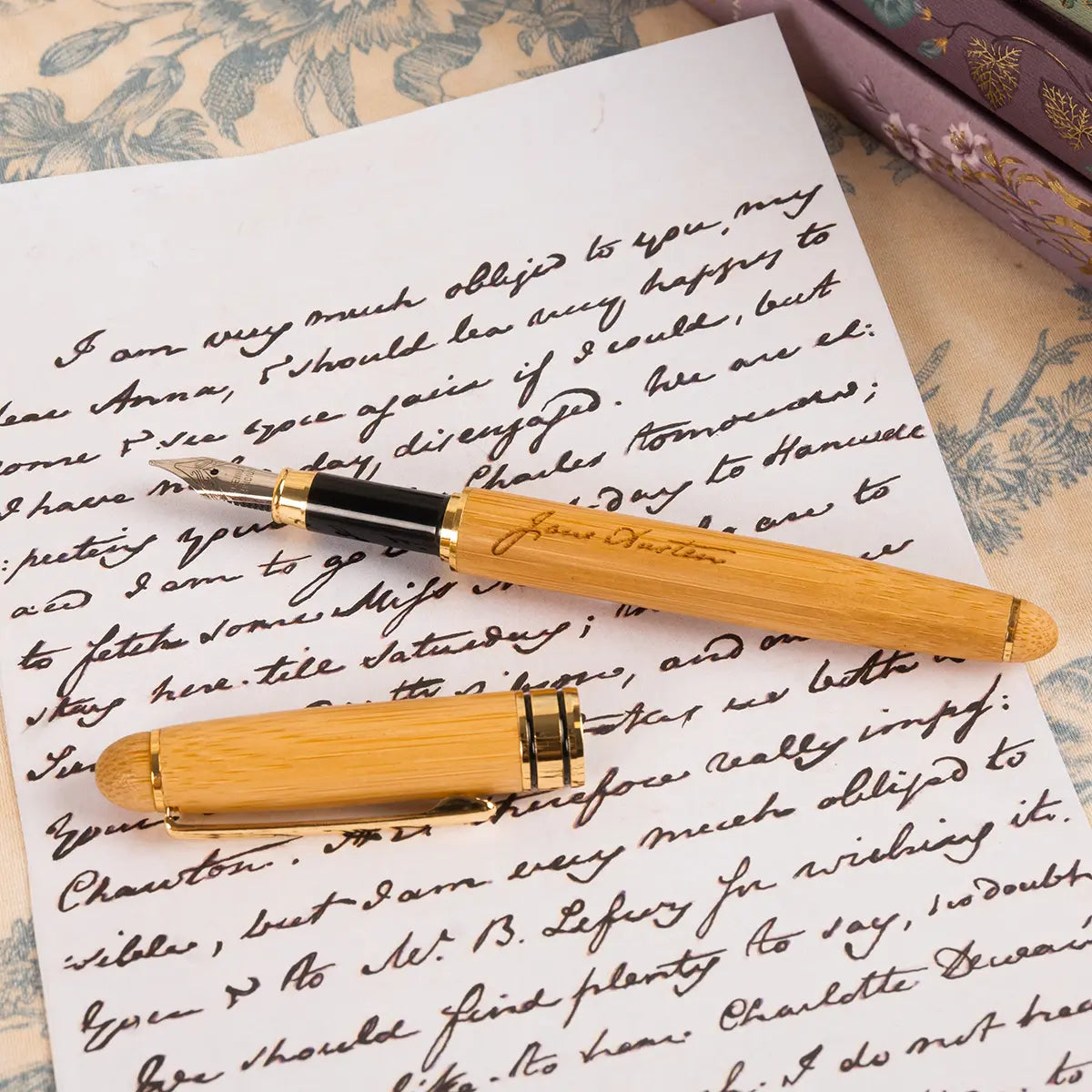 A wooden Jane Austen themed fountain pen, open, on a letter