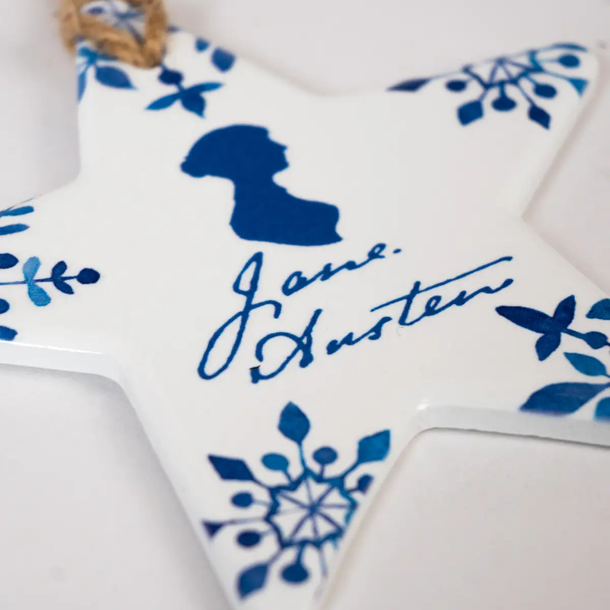 Angled close up shot of Jane austen themed white and blue star shaped christmas tree decoration